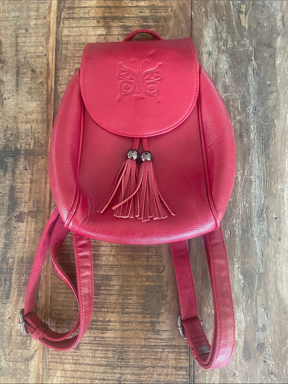 Textured Red Leather Backpack with Embossed Butterfly and Tassel Accent